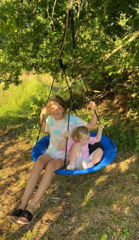Kids enjoying the swing under the oak tree