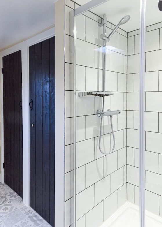 The walk-in shower, showing the low step into the shower tray and the height-adjustable shower head