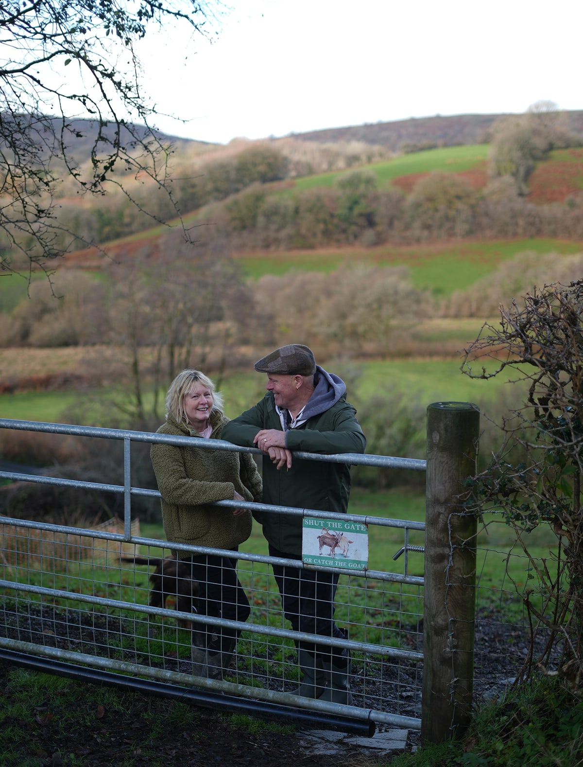Friendly couple smiling with a beautiful rural valley view behind them